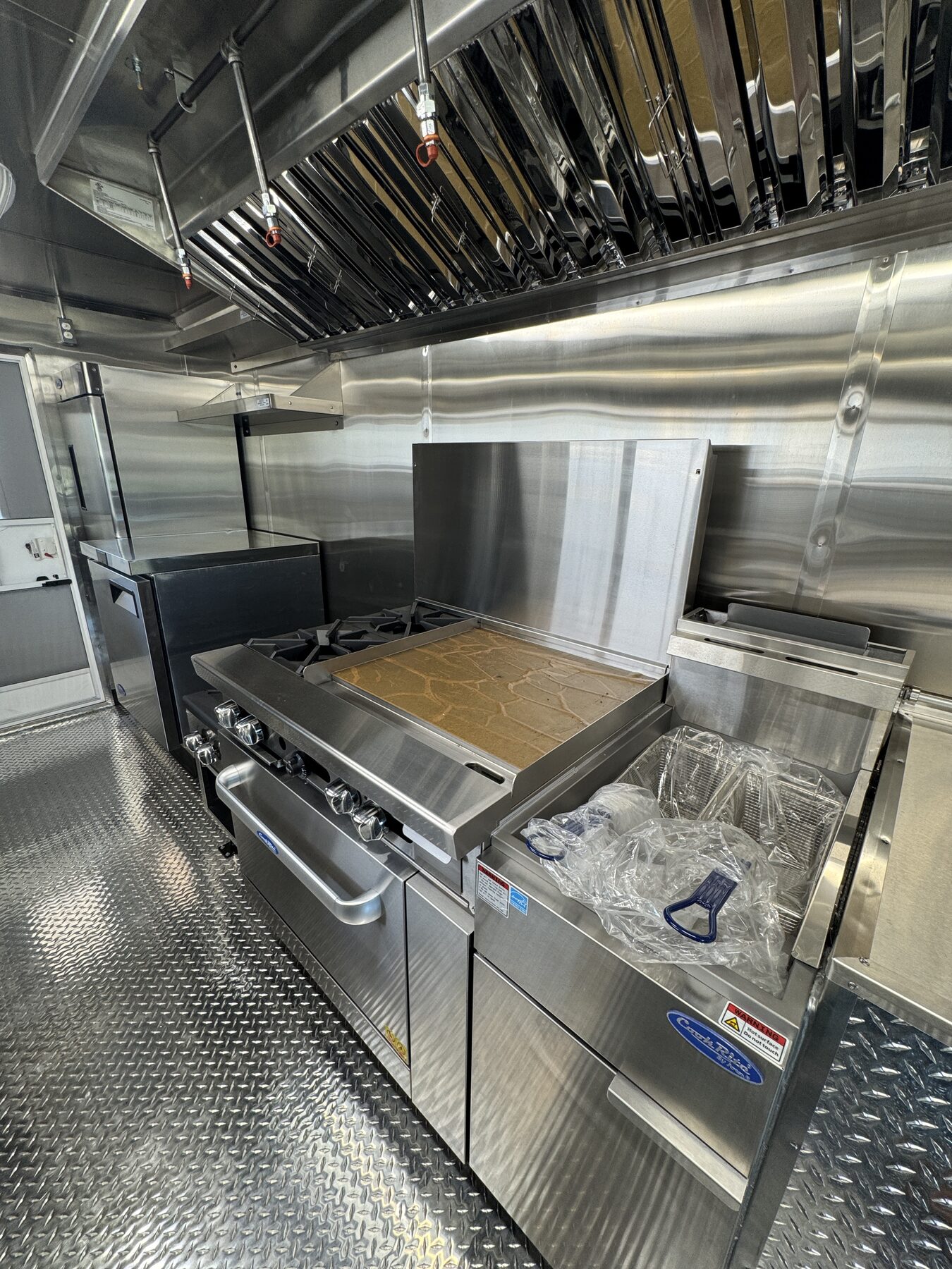 Atosa range with griddle and a 40 pound fryer under the six foot Type 1 hood