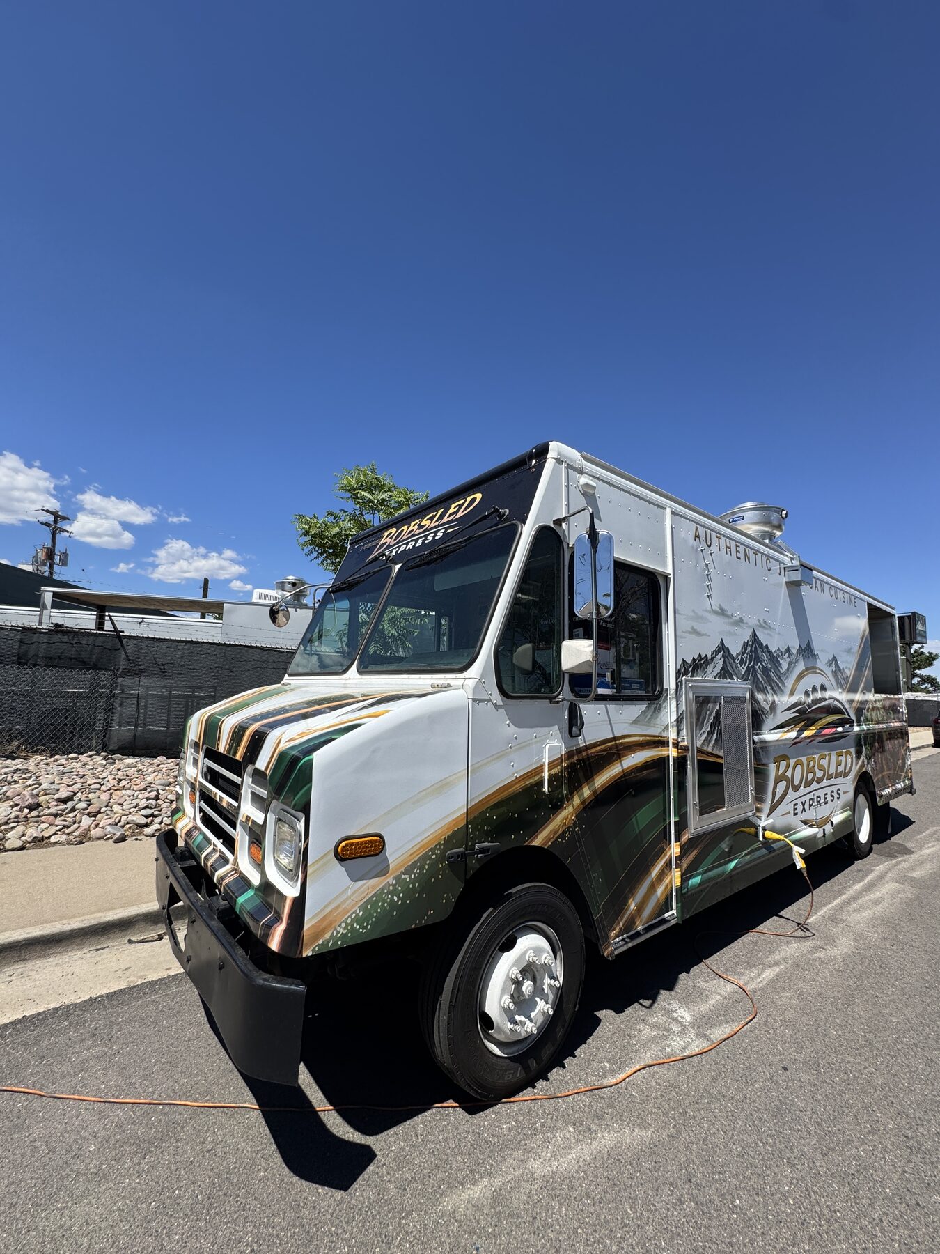 Front of the finished Jamaican food truck plugged into fifty amp shore power