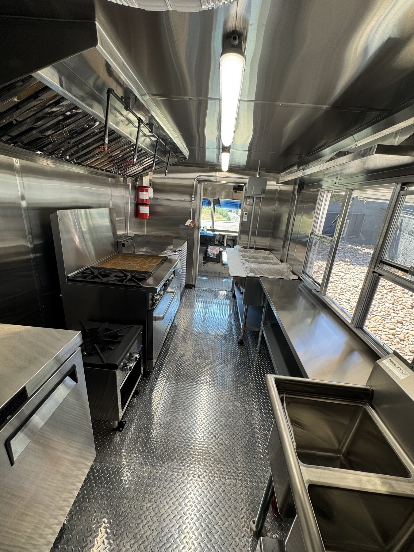 Interior of the twenty foot Jamaican food truck looking forward along the cook line