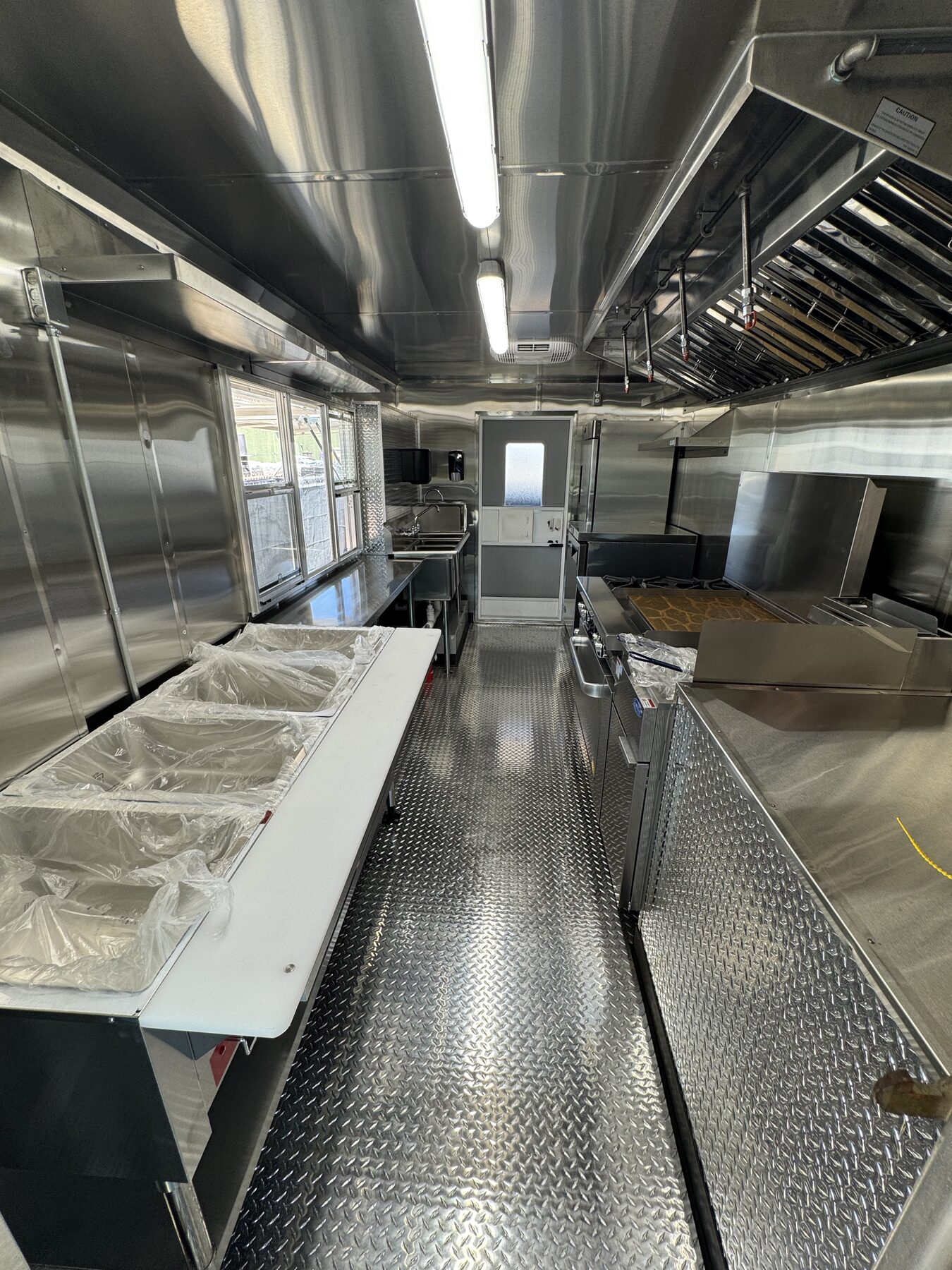 Stainless counter and steam table pans under the three section service window