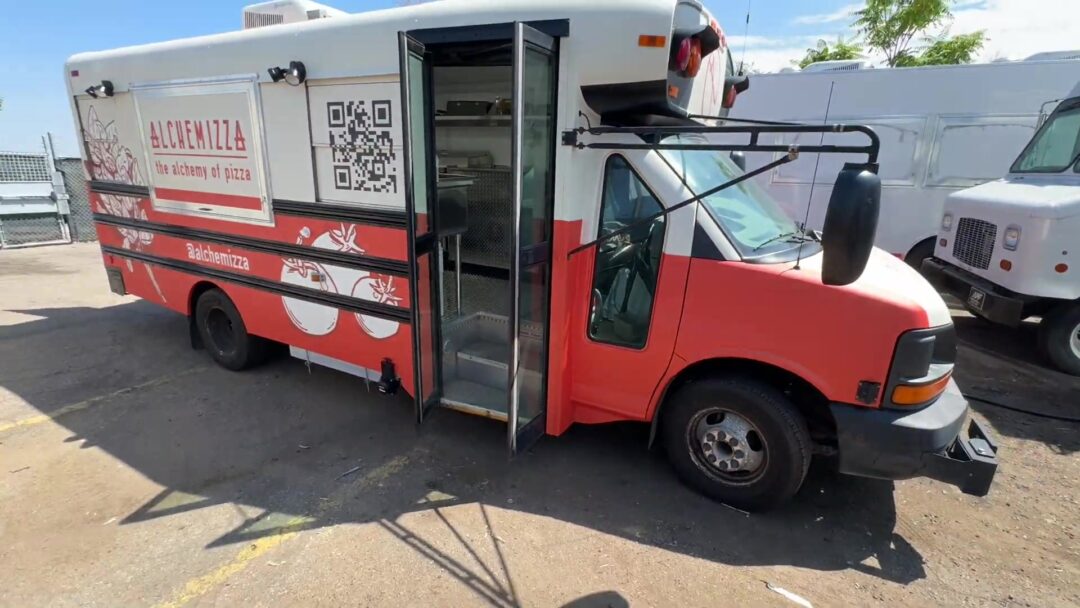 Alchemizza 14ft pizza food bus in a red and white wrap with the side door open, built for Boulder, Colorado