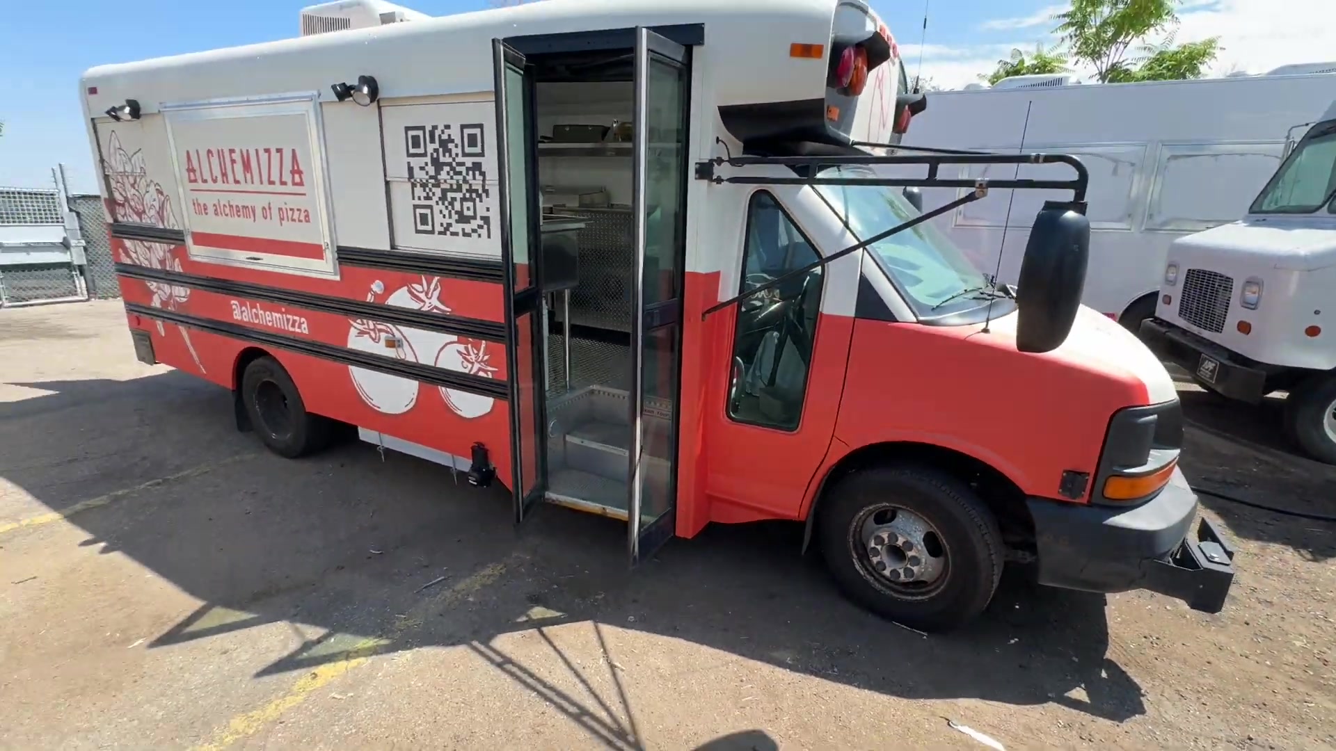 Alchemizza 14ft pizza food bus in a red and white wrap with the side door open, built for Boulder, Colorado