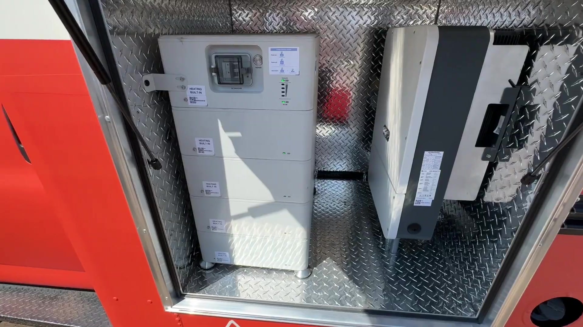 Stacked lithium battery bank with built in heating and an inverter inside the old generator box of the food bus