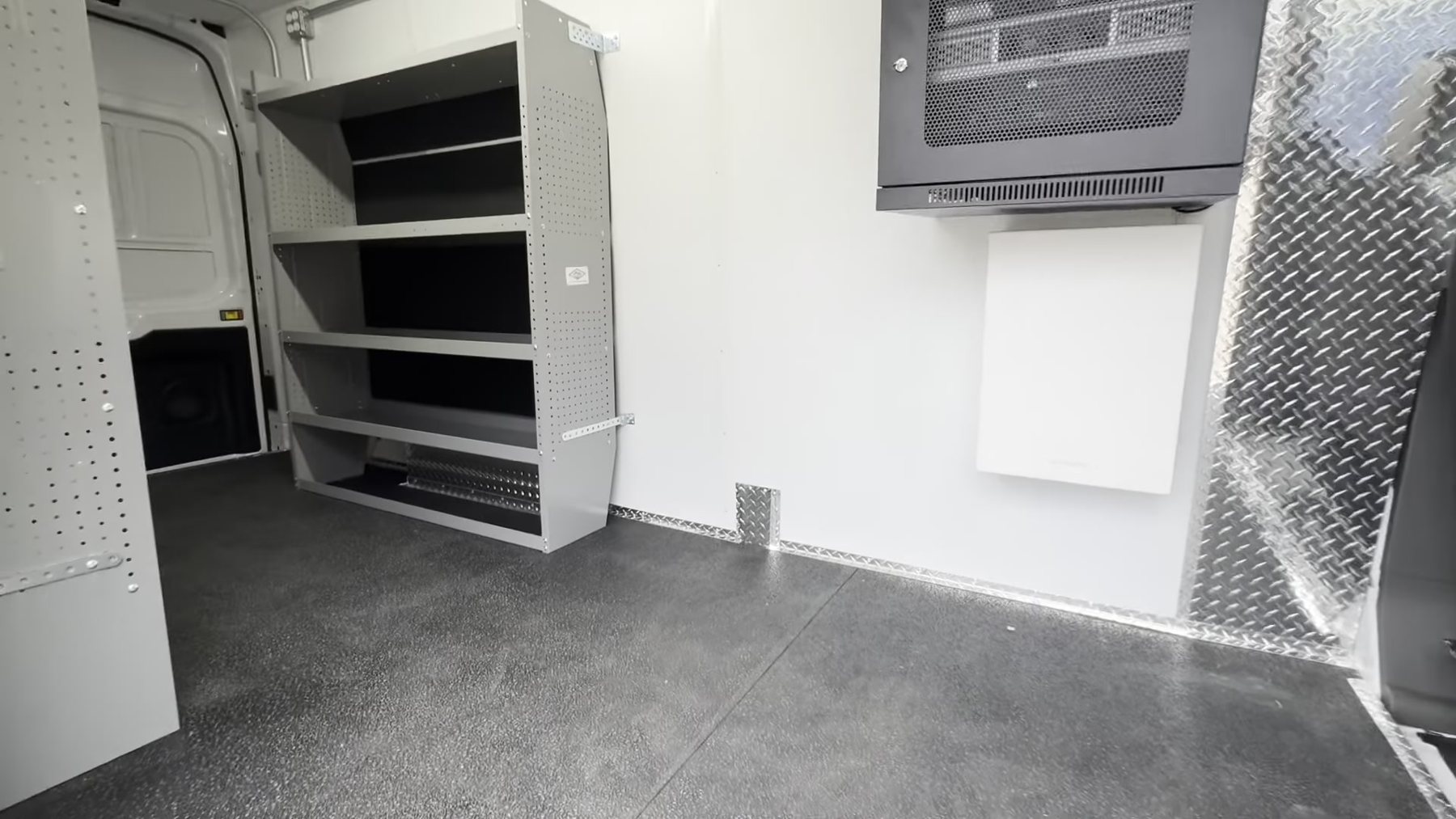 Interior of the mobile outreach van with shelving, a wall mounted screen and a rubber floor