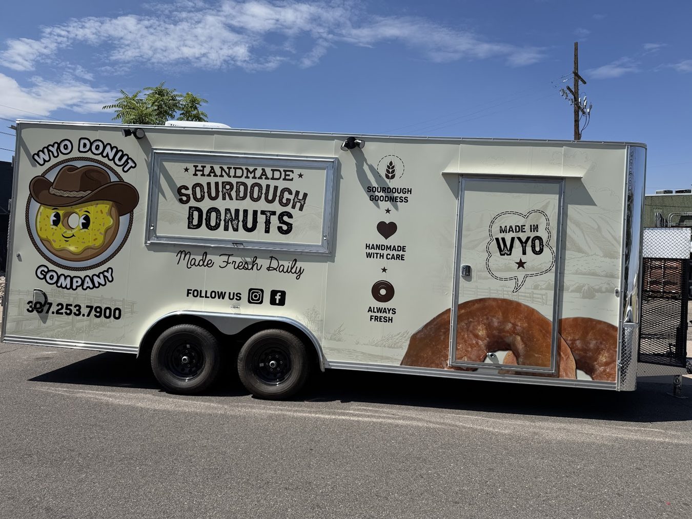 Driver side of the 20 foot donut trailer showing the wrap, the entry door and the generator box
