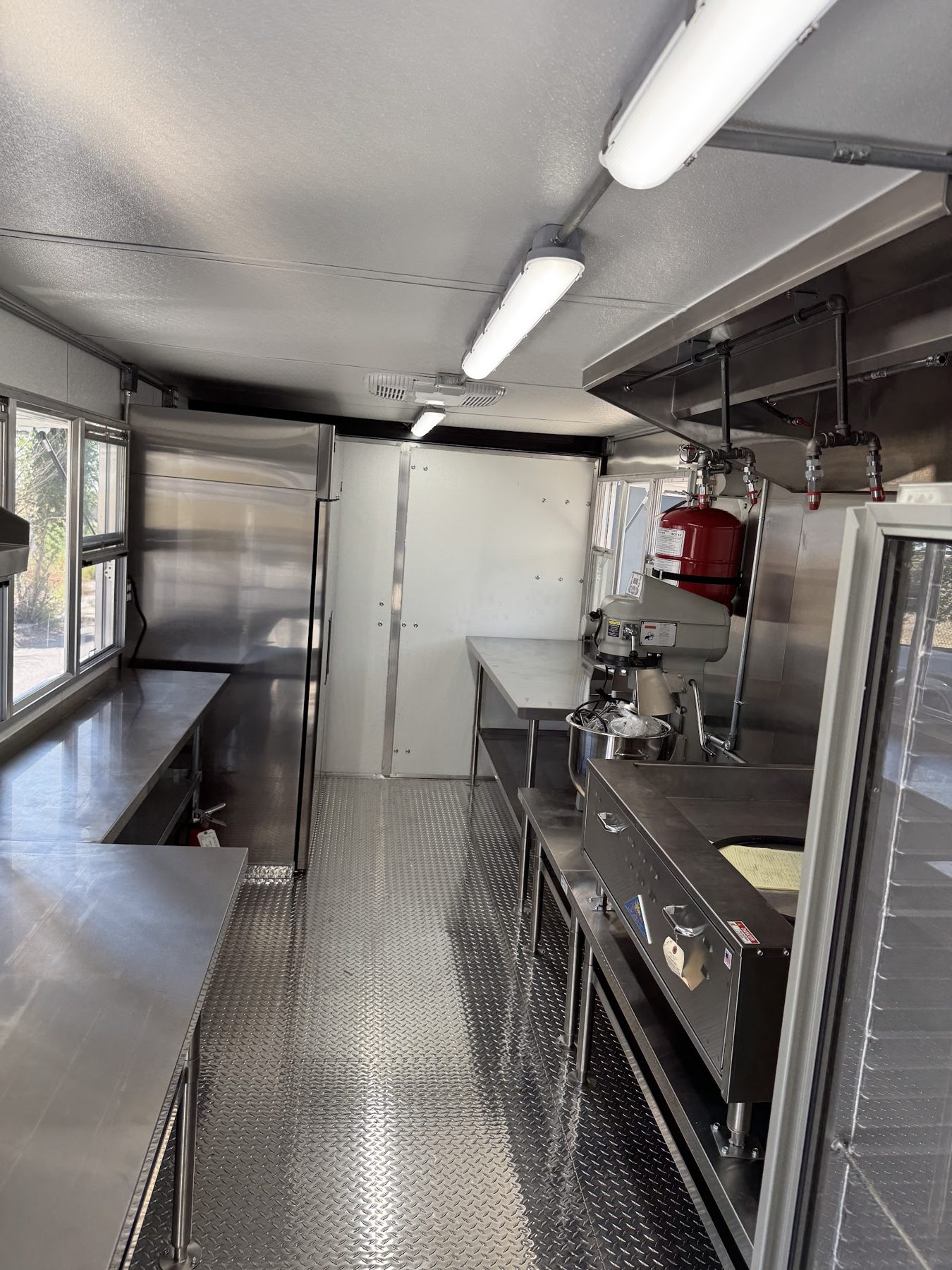 Cook line inside the donut trailer with the flat donut fryer and stand mixer under the Type 1 hood