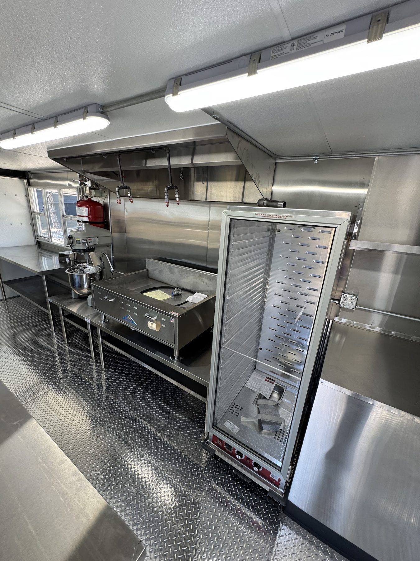Proofing cabinet on casters beside the cook line under the hood in a 20 foot donut trailer