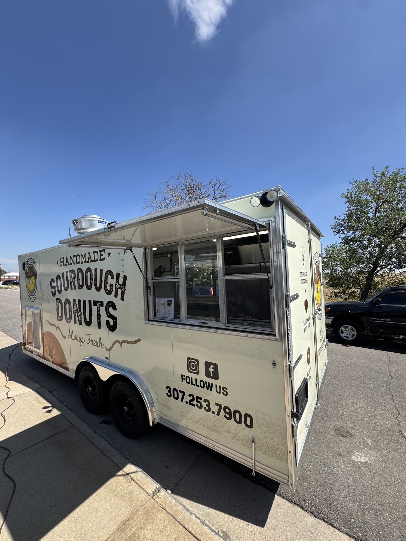 Donut trailer with both service windows open and the awning up, ready to serve